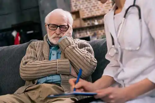 a depressed old man silently listening to a doctor